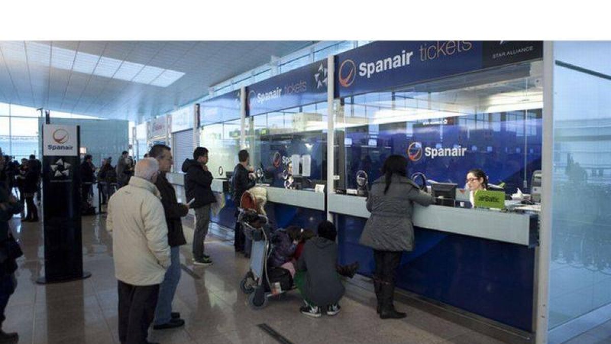 Pasajeros de Spanair, ante los mostradores de la compañía, el sábado, en el aeropuerto de El Prat.