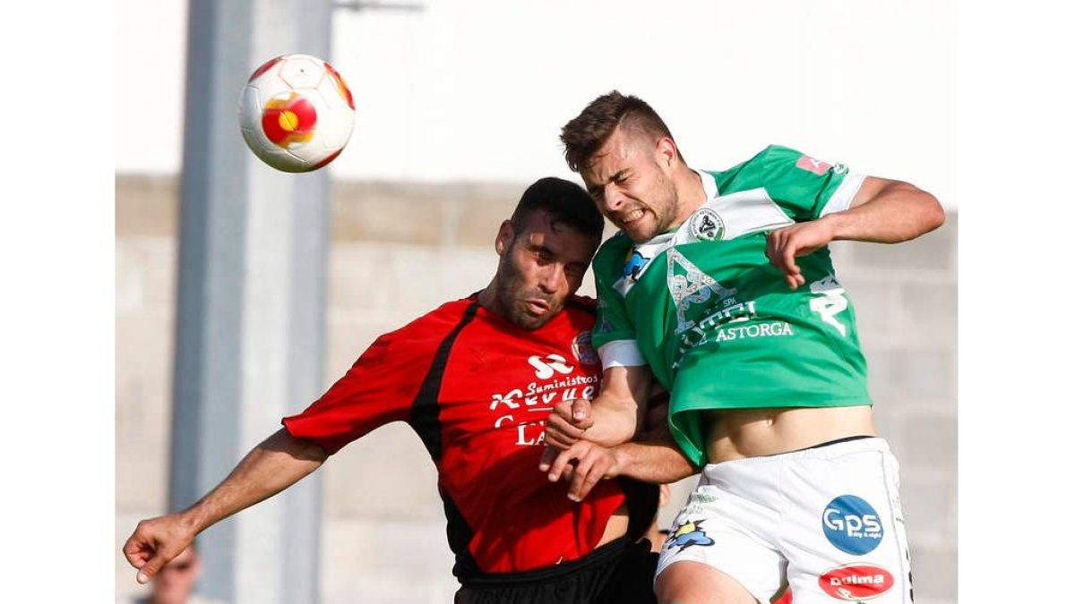 Cristian, a la derecha, despeja un balón de cabeza a pesar de la oposición de un jugador laredano