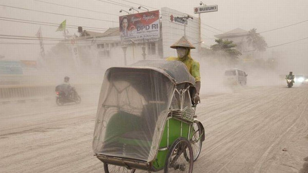 Un indonesio circula por una carretera de Yogyakarta cubierta de ceniza y arena del volcán Kelud, este viernes.