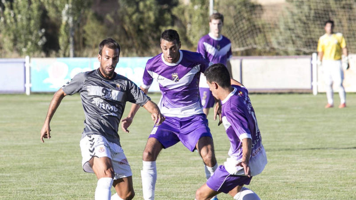 El centrocampista de la Cultural Nacho Matador conduce el esférico ante la oposición de dos futbolistas del CD Becerril.