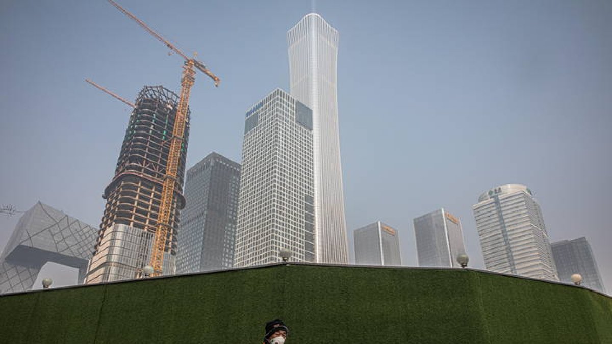 Un trabajador municipal en Beijing, en una zona afectada por el Covid-19. ROMAN PILIPEY