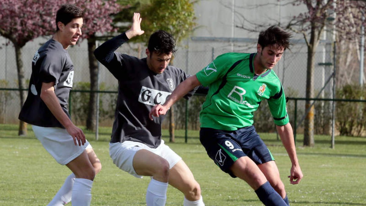 Puente, a la derecha, se lleva el balón a pesar de la oposición de dos jugadores contrarios.