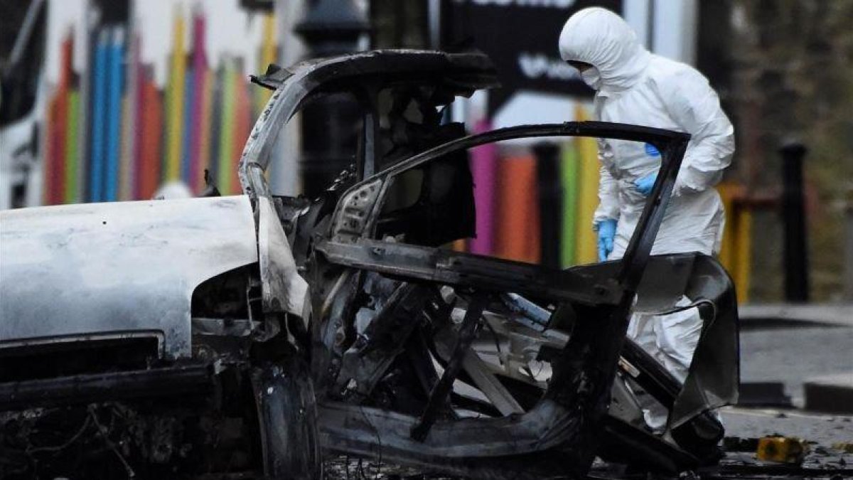 Un forense inspecciona la zona donde ha explotado el coche bomba en Londonderry.