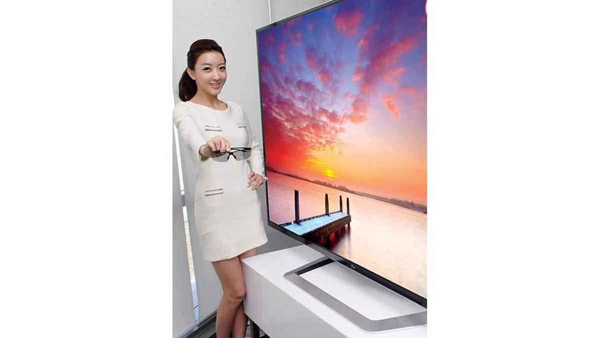 Una modelo posa junto a un televisor de alta definición y 3D.