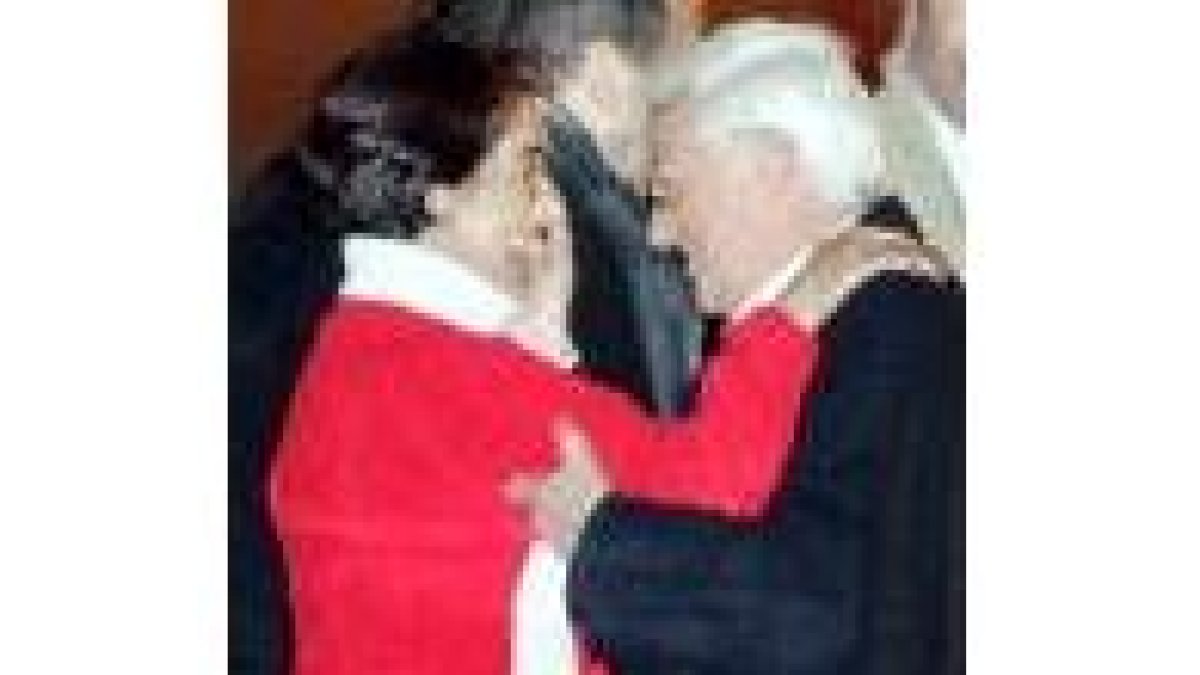 Mercedes García saluda sonriente al padre Ángel tras bajar del avión el jueves en Torrejón