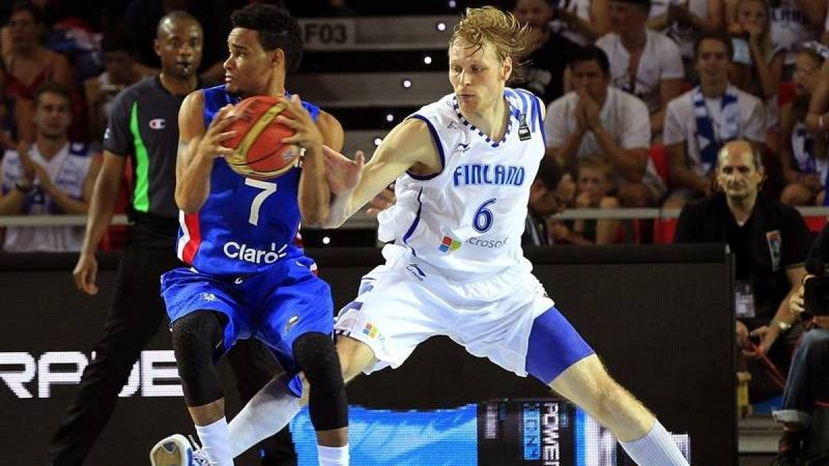 El pívot finlandes Tuukka Kotti(i) lanza a canasta con la oposición del pívot dominicano Jack Martinez(d) durante el partido de la tercera jornada de la Copa del Mundo de Baloncesto 2014, grupo C, que las selecciones de Finlandia y República Dominicana di