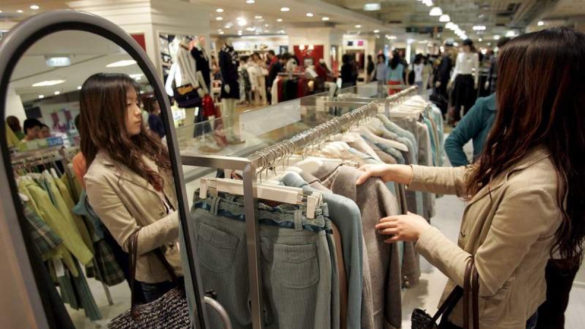 Una mujer ojea un pantalón en un centro comercial chino. MICHAEL REYNOLDS
