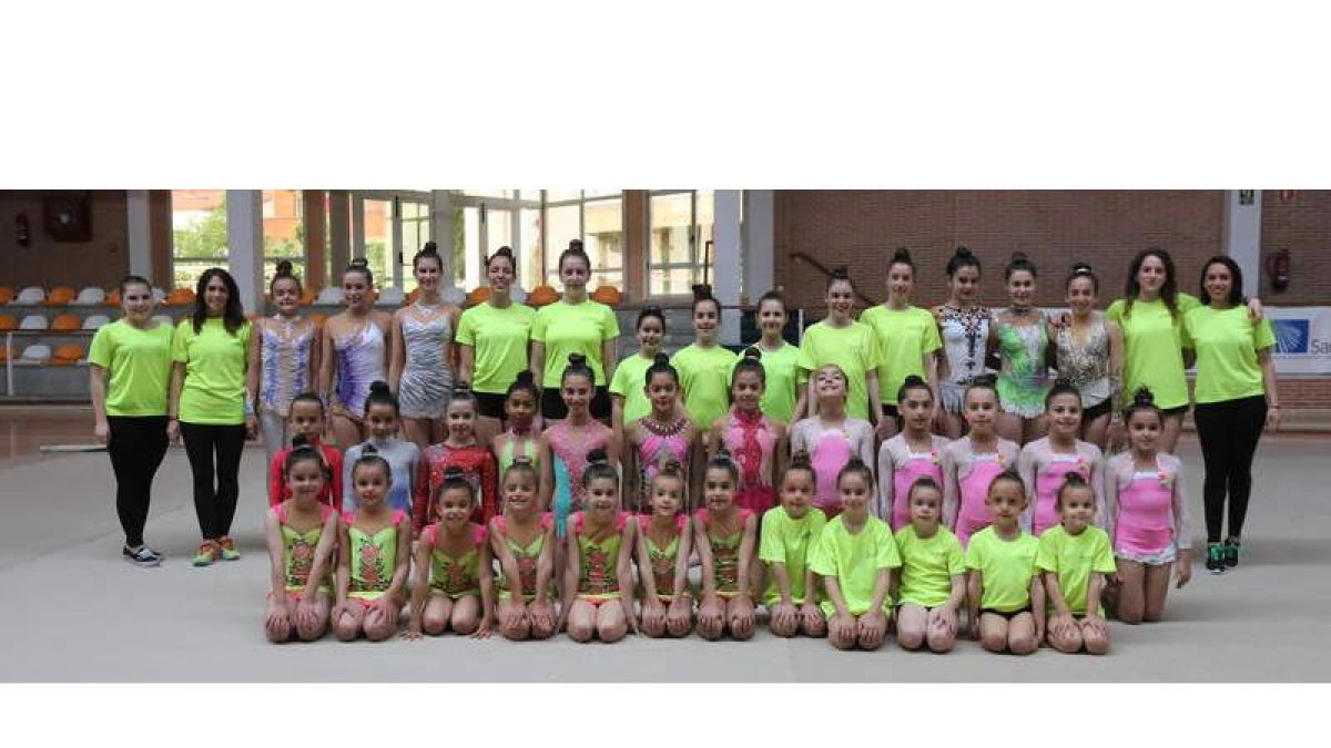 Imagen de familia de las 55 gimnastas que entrenan con el Club Armonía junto con su grupo de entrenadoras en el pabellón Camino de Santiago de San Andrés