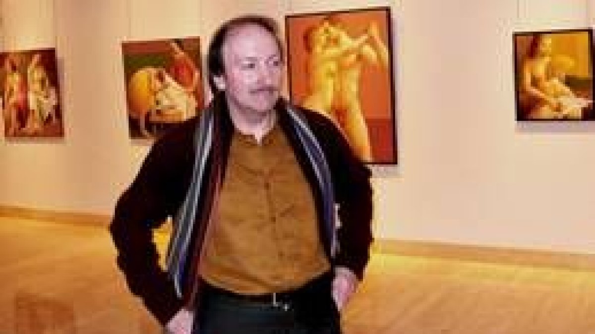 El artista leonés Vicente Gutiérrez Tascón posa ante las obras que expone en Caja España