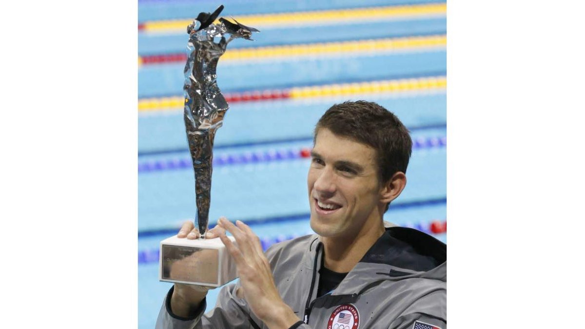 Phelps muestra exultande el trofeo que le acredita como el mejor nadador de todos los tiempos.