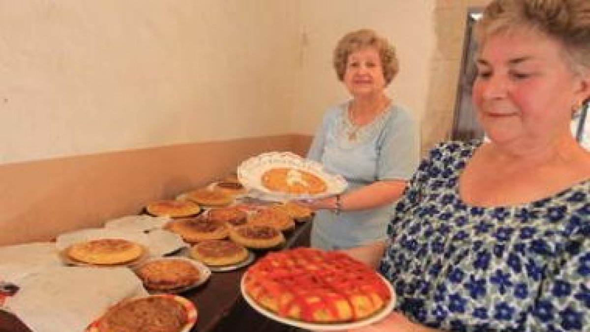 Dos de las participantes en el concurso de tortillas muestran orgullosas sus piezas.