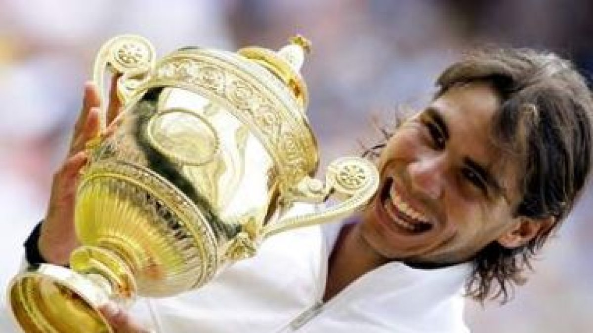 El tenista español Rafael Nadal sostiene sonriente su trofeo tras su victoria sobre el checo Berdych