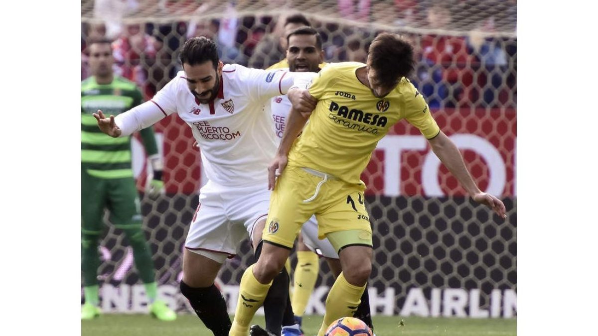 El defensa galo del Sevilla, Adil Ramí, disputa un balón a Trigueros, jugador del Villarreal. RAÚL CARO