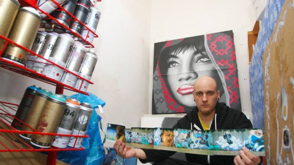 Asier Vera, graffitero al que la cadena infantil Boing ha fichado para diseñar los grafísmos de su nuevo programa, 'Selfie Show', junto a varias de sus obras y materiales de trabajo en su estudio en Ponferrada