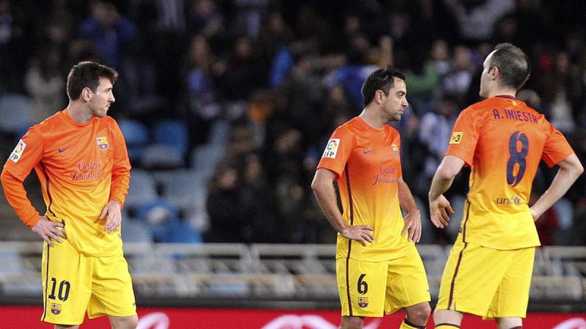 Messi, Xavi e Iniesta, cariacontecidos en el centro del campo tras encajar el Barça el tercer gol.