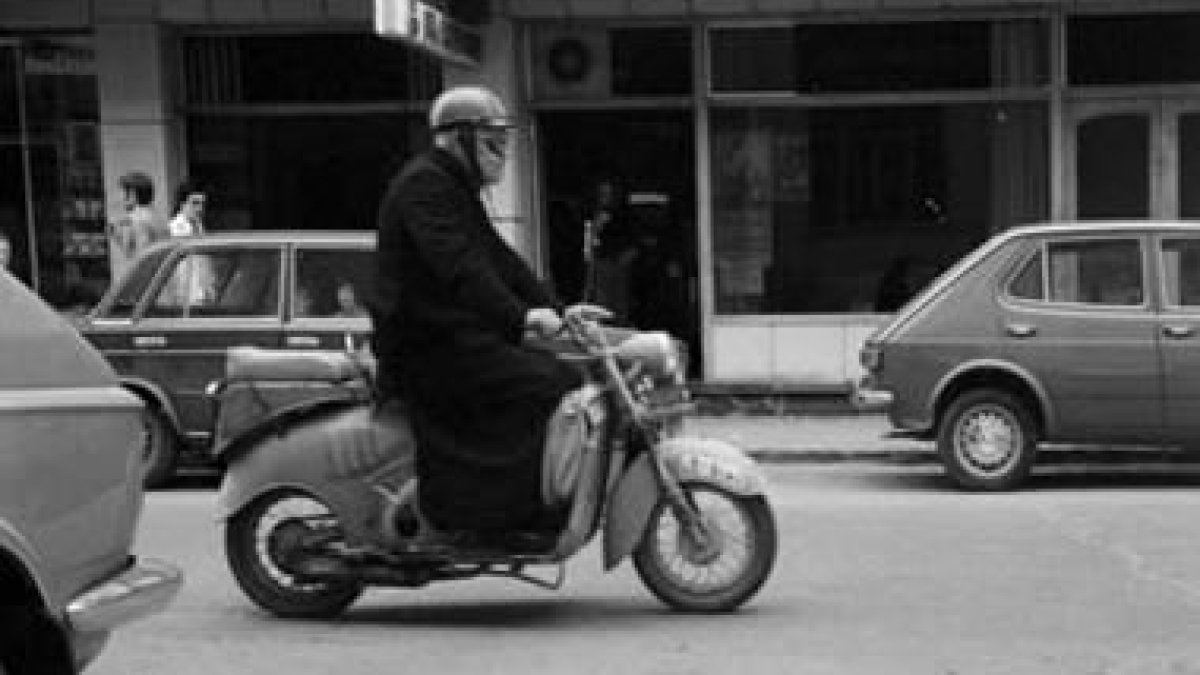 Un cura conduce una moto en Astorga en los años de la Transición.