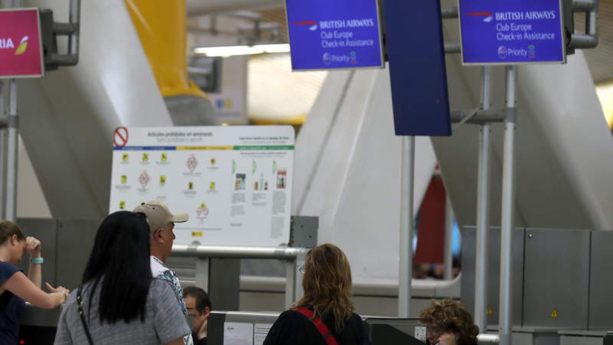 Varias personas en los mostradores de BA en el aeropuerto Adolfo Suárez Madrid-Barajas. S. BARRENECHEA