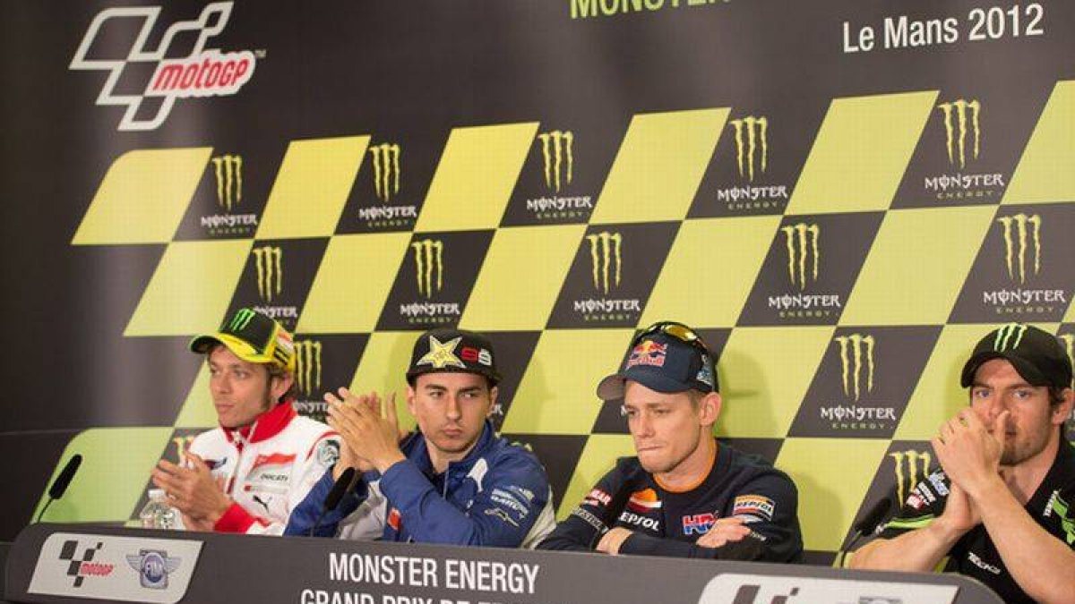Valentino Rossi, Jorge Lorenzo y, a la derecha, Cal Crutchlow aplauden a un cariacontecido Casey Stoner, que acaba de anunciar que se va (Le Mans, 17 de mayo).