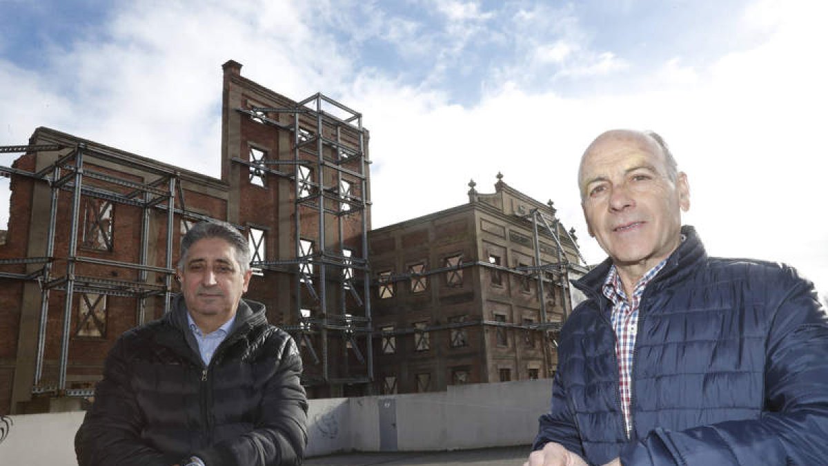 Miguel Ángel Cueto Carretero y Enrique Macarrón Valcarce con la fachada de la Azucarera Santa Elvira de fondo. JESÚS F. SALVADORES