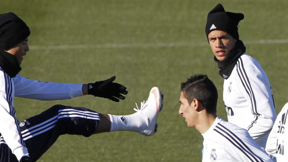 Cristiano (i) Di Maria (d) junto al francés Varane durante el entrenamiento del Real Madrid.
