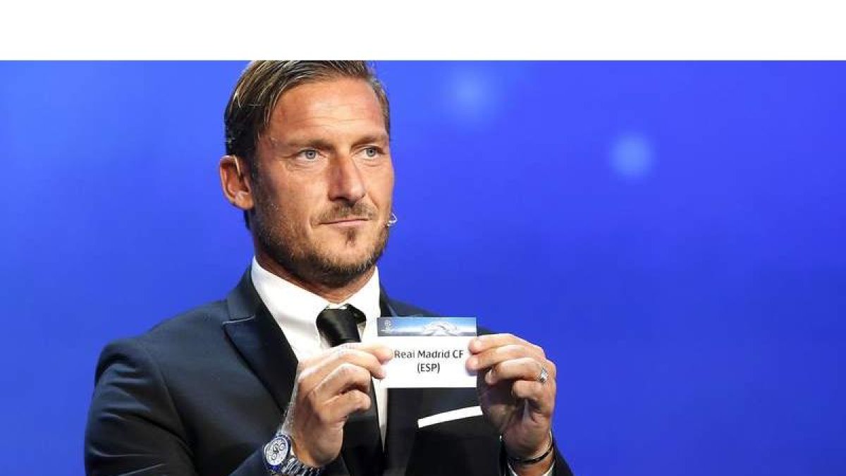 El exfutolista de la Roma Francesco Totti muestra la papeleta del Real Madrid durante el sorteo de la Liga de Campeones. SEBASTIEN NOGIER
