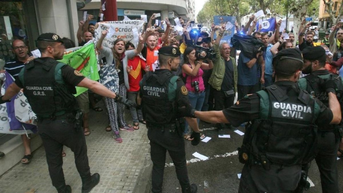 Guardias civiles ante un grupo de manifestantes, durante el registro del semanario El Vallenc