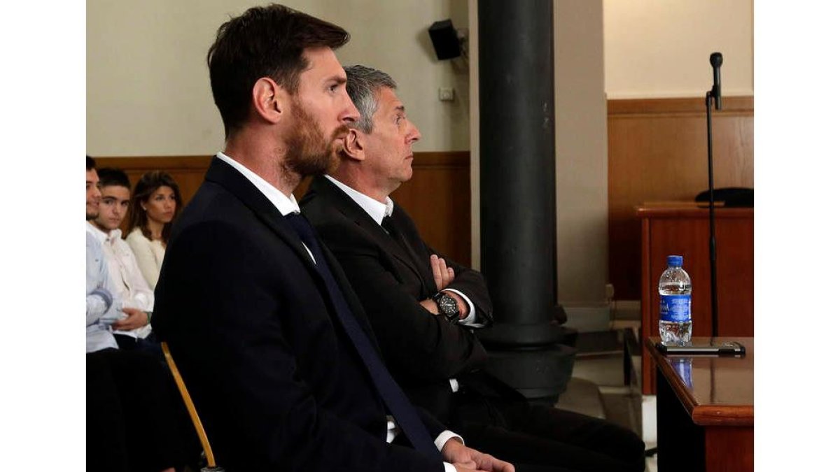 Messi, junto a su padre, durante el juicio en la Audiencia Provincial de Barcelona. ALBERTO ESTÉVEZ