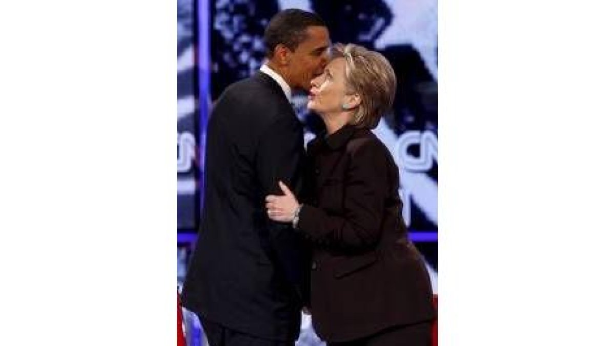 Obama le comenta a Clinton al oído algún tema al final del cara a cara