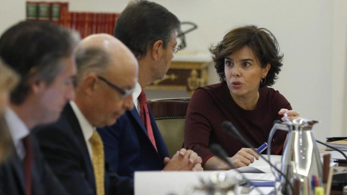 Soraya Sánez de Santamaría conversa con Rafael Catalá, junto al ministro Cristóbal Montoro e Íñigo de la Serna, este sábado, al inicio del Consejo de Ministros extraordinaro.