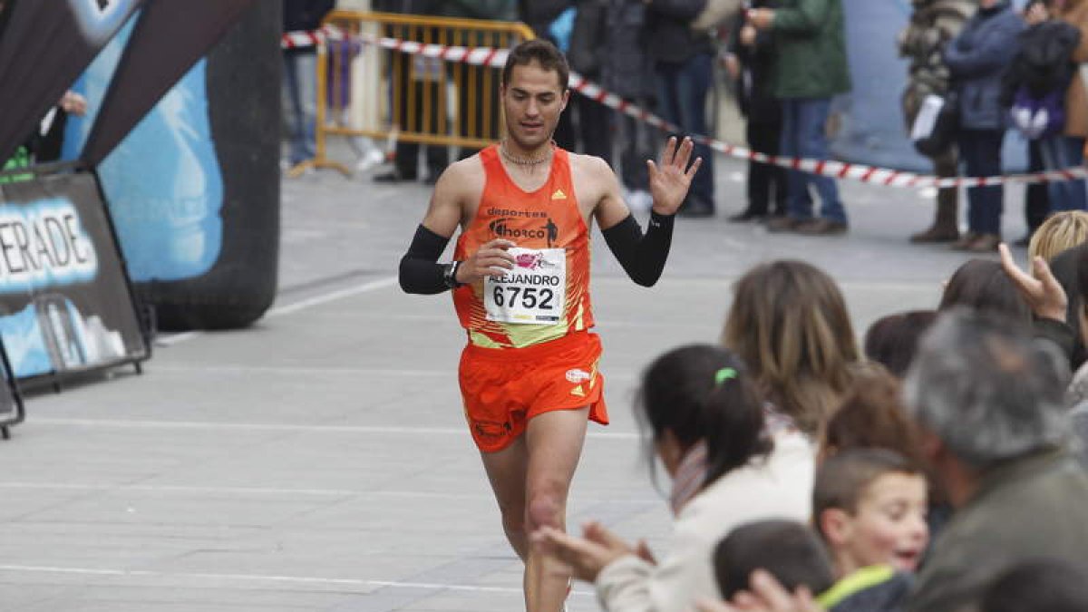 Álex Martínez levanta su mano izquierda en el momento de cruzar la meta como vencedor.