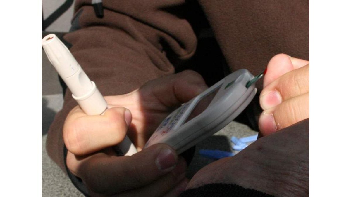 Un paciente realiza una prueba de glucosa tomando una muestra de sangre en el dedo.