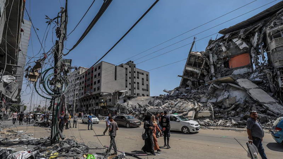 Vecinos de una de las calles de Gaza atacadas por Israel caminan entre los escombros. MOHAMMED SABER