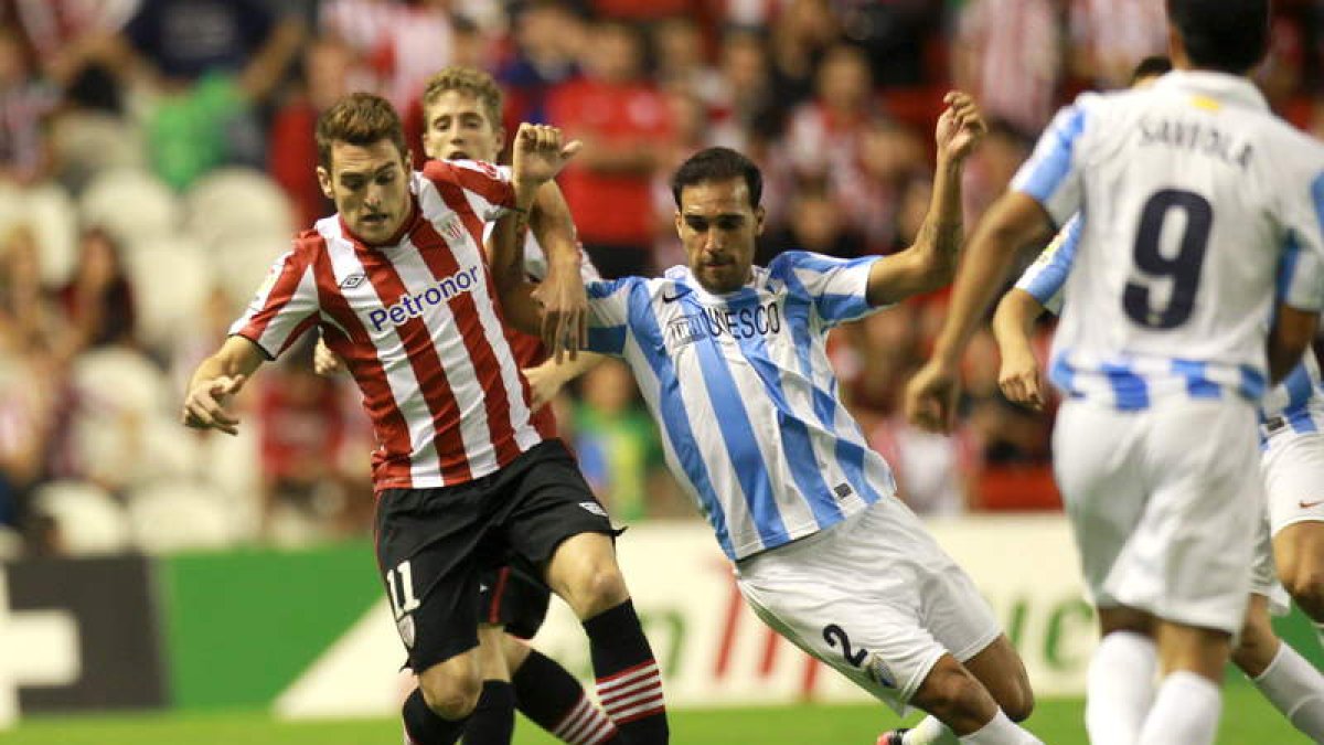 El futbolista del Athletic Ibai Gómez intenta marcharse del defensa del Málaga Jesús Gámez.