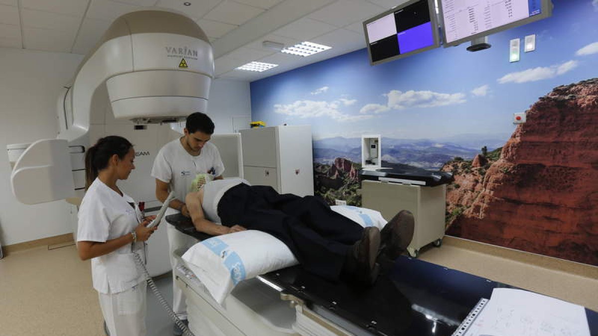 El equipo de radioterapia oncológica prepara a un paciente para recibir tratamiento en el nuevo acelerador lineal del Hospital de León. MARCIANO