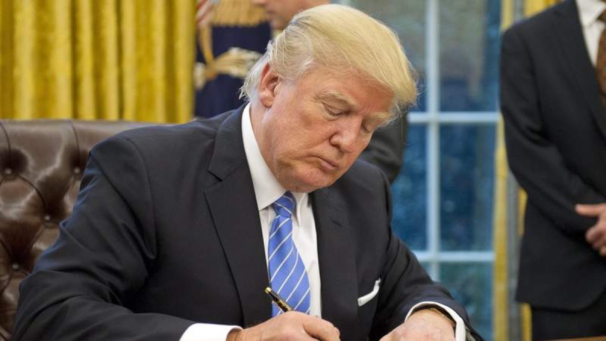 Donald Trump firma un documento en su despacho de la Casa Blanca. RON SACHS