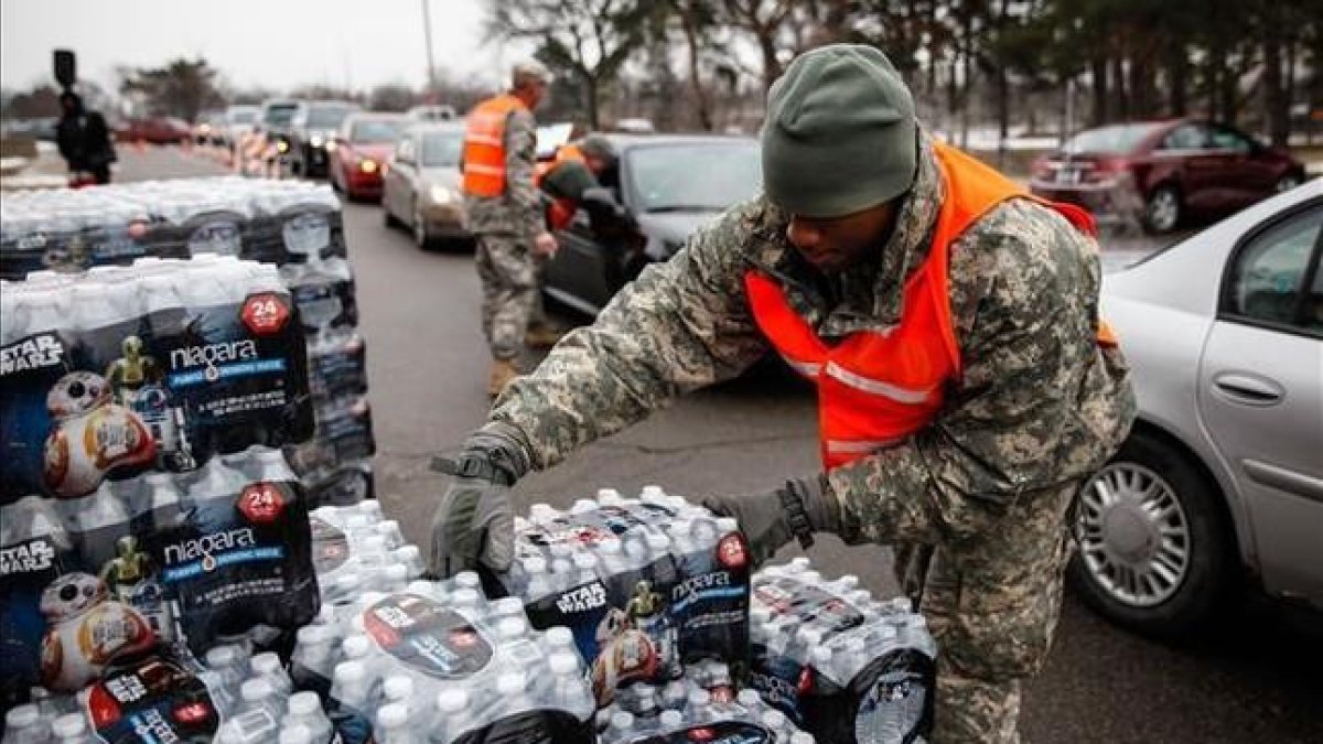Efectivos de la Guardia Nacional reparten agua embotellada a los habitantes de Flint.