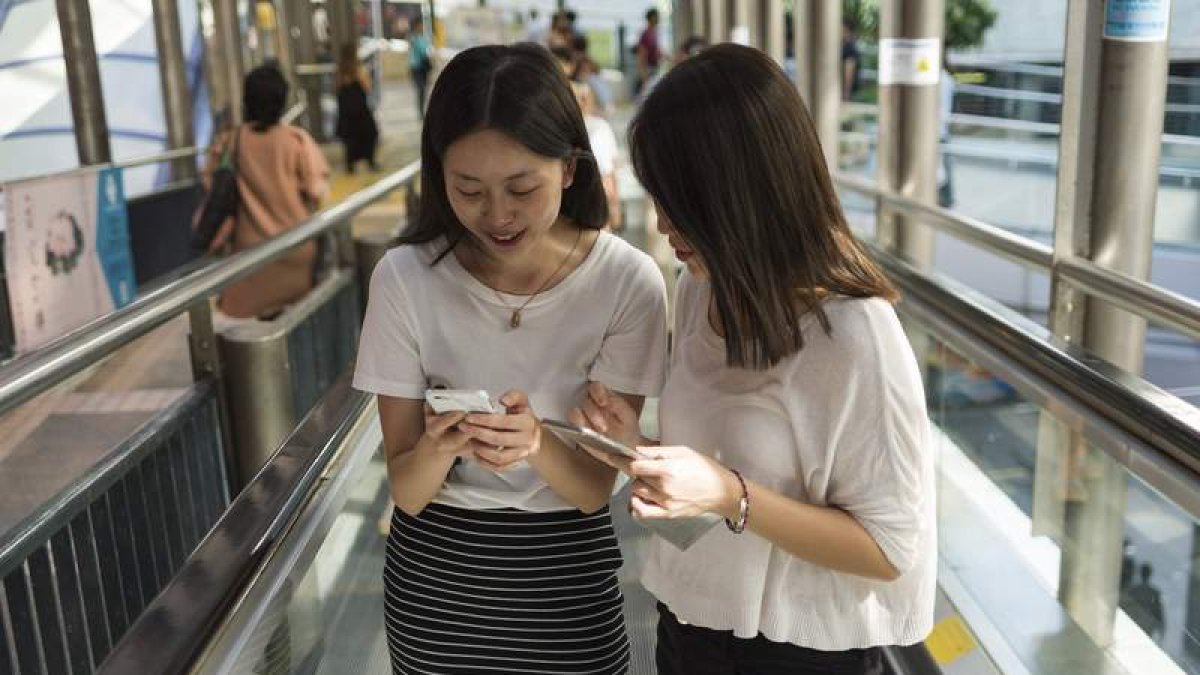 Dos mujeres revisan sus ‘smartphones’. JEROME FAVRE