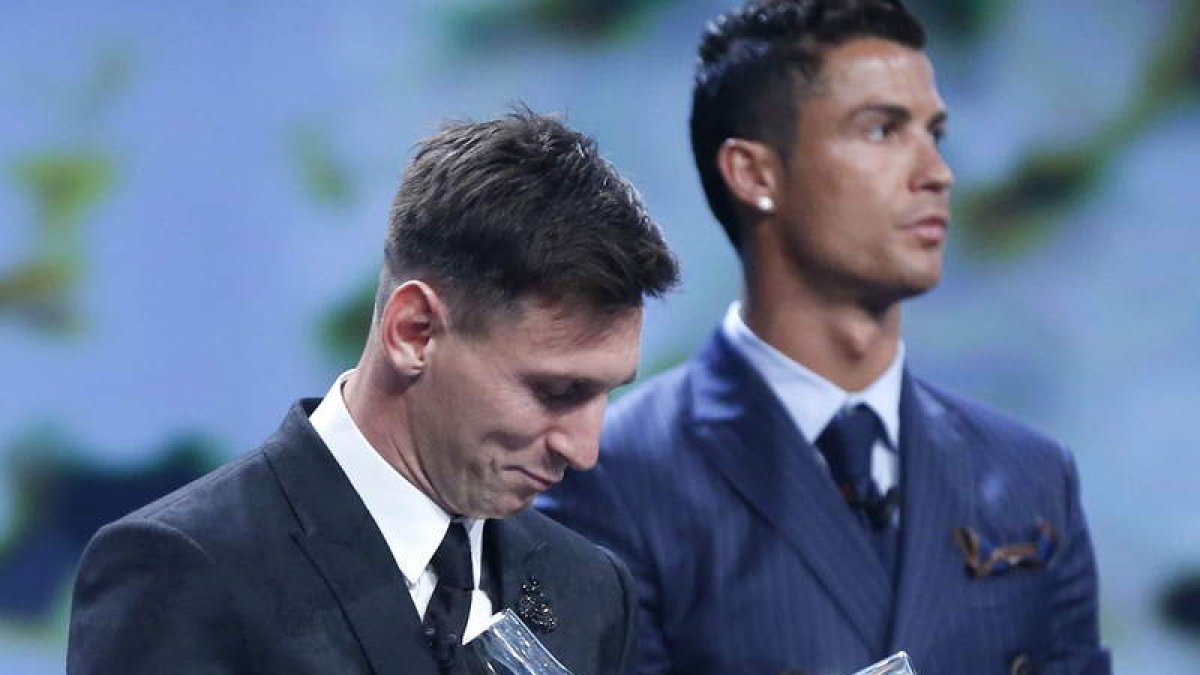 Leo Messi con su trofeo al mejor jugador de la Uefa sonríe con Cristiano de fondo