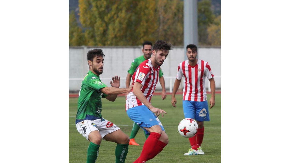 Taranilla, a la izquierda, trata de arrebatar el balón a un jugador rojiblanco. ANA F. BARRERO
