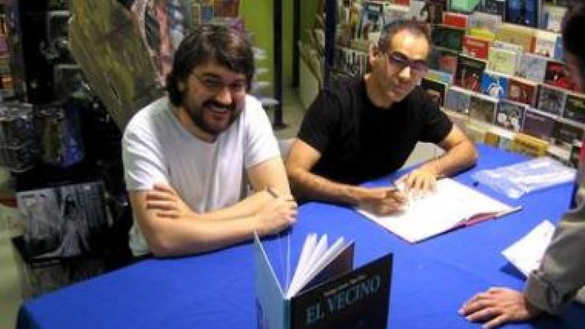 Pepo Pérez (derecha) y Santiago García (izquierda) firmando ejemplares de su serie «El Vecino&