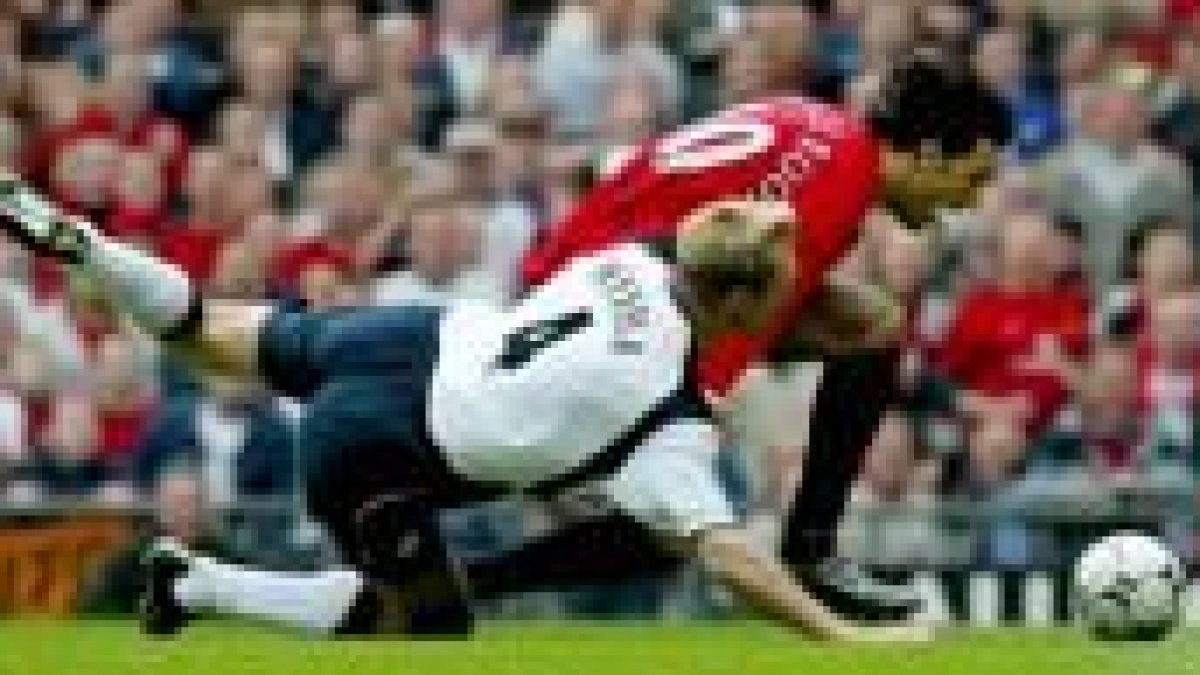 Hyypia y Van Nistelrooy luchan por hacerse con el control de un balón