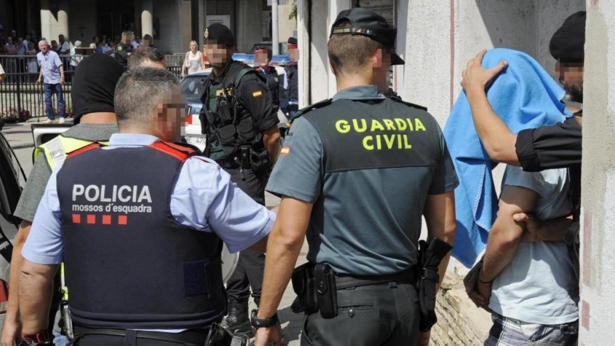Guardia Civil y Mossos d Esquadra se llevan a un detenido, esta mañana, en Ripoll.