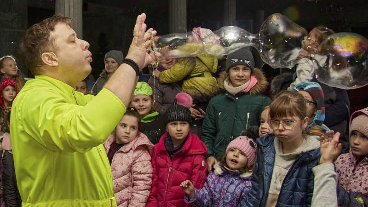 Un miembro de emergencias entretiene a los niños con pompas de jabón en Kharkiv en un bombardeo. SERGIY KOZLOV