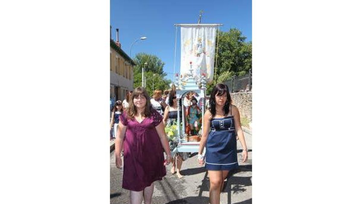Dos jóvenes portan la imagen del santo en la procesión.