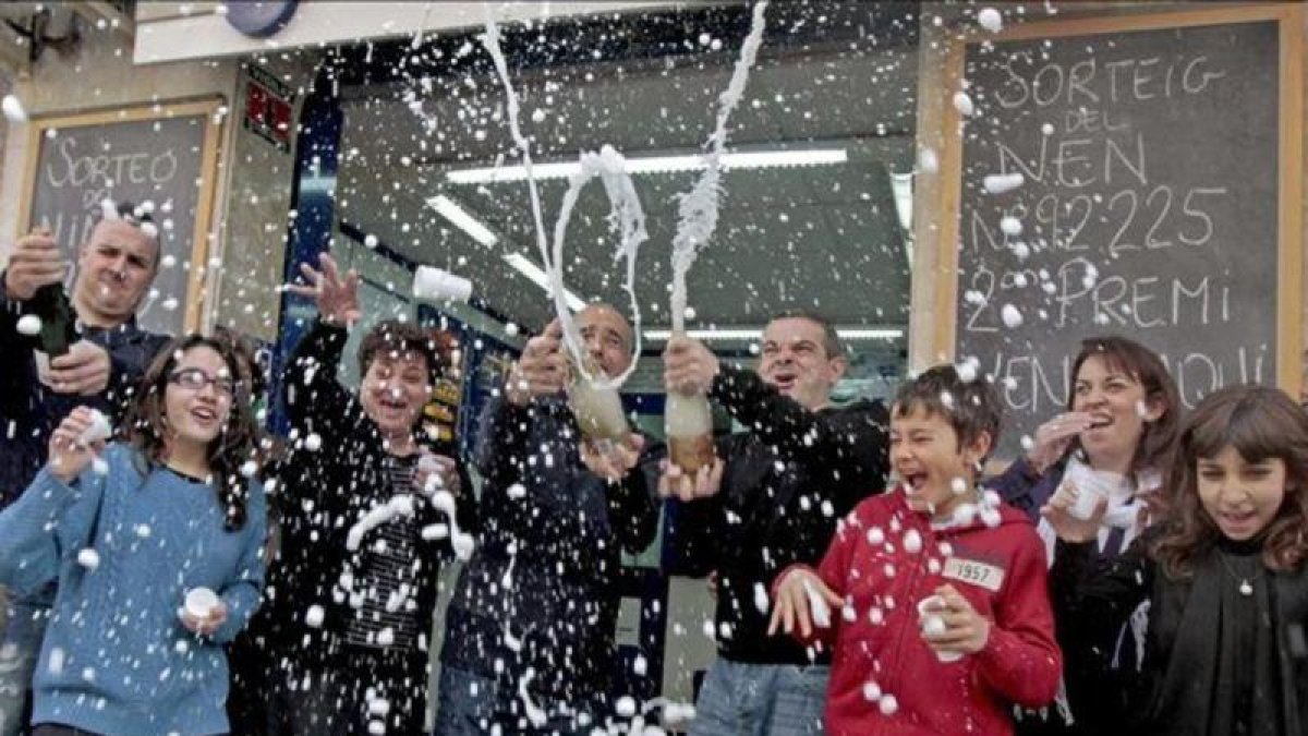 Los propietarios de una administración de lotería del Hospitalet de Llobregat celebran el haber vendido dos series premiadas.