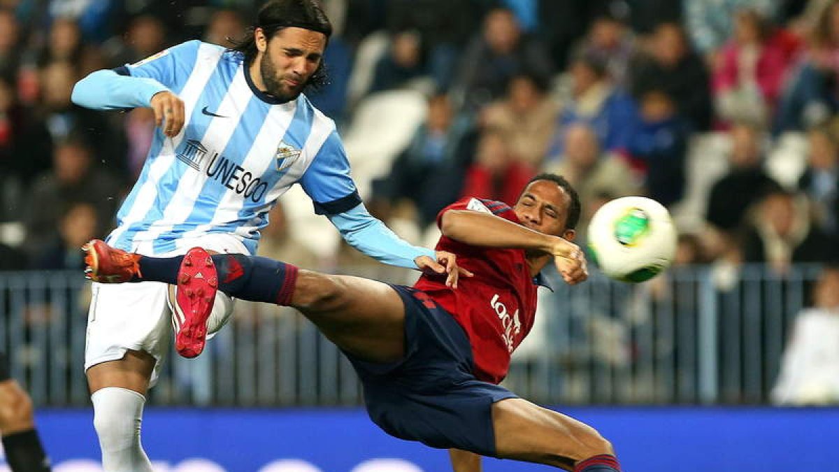 El delantero de Osasuna, Manuel Onwu, cae ante el jugador del Málaga, Sergio Sánchez.