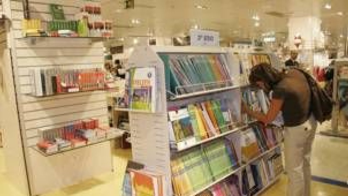 Una madre observa los libros de texto de tercero de la ESO, en un centro comercial de la capital