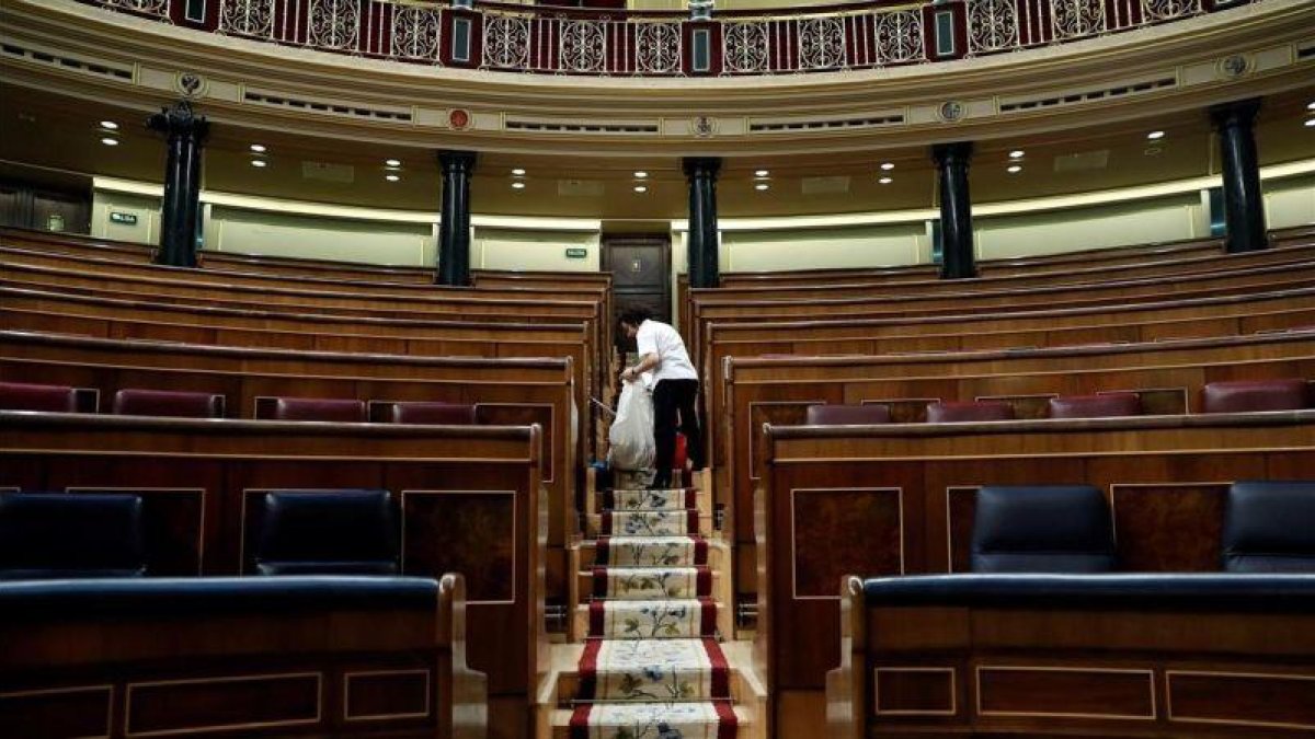 Labores de limpieza en el hemiciclo del Congreso de los Diputados, tras quedarse vacío el pasado 28 de febrero.
