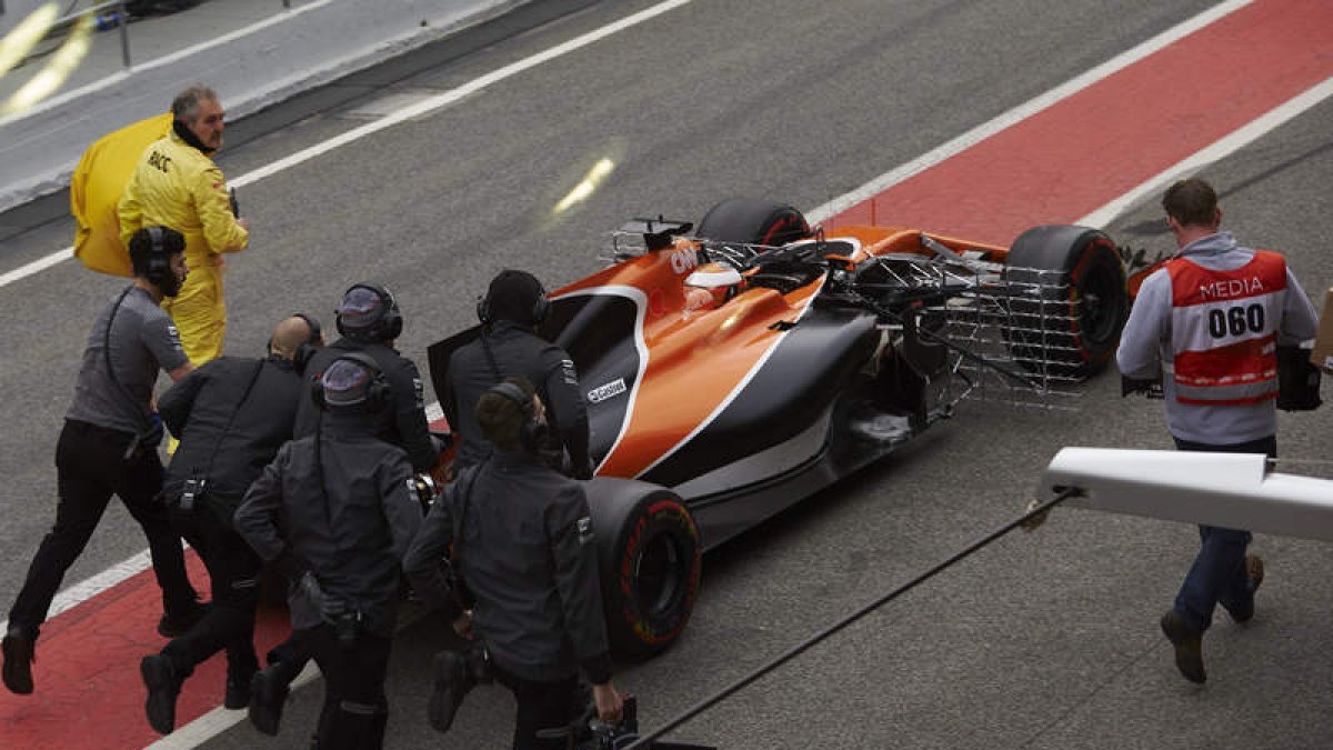 El McLaren es remolcado por los mecánicos en la segunda jornada de entrenamientos libres. A. GARCÍA