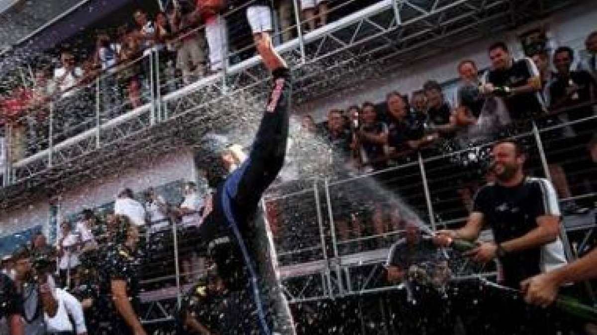El piloto australiano Mark Webber (centro), de Red Bull, celebra su triunfo junto a su equipo.